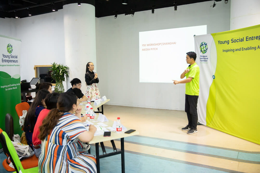 With the help of a sign-language interpreter, workshop participant Shiqun Hu, Co-founder of UDS Art Office, inspires the panel at the Media Pitching Session with the story of how his team of hearing-impaired artists makes a mark in the world of art and business