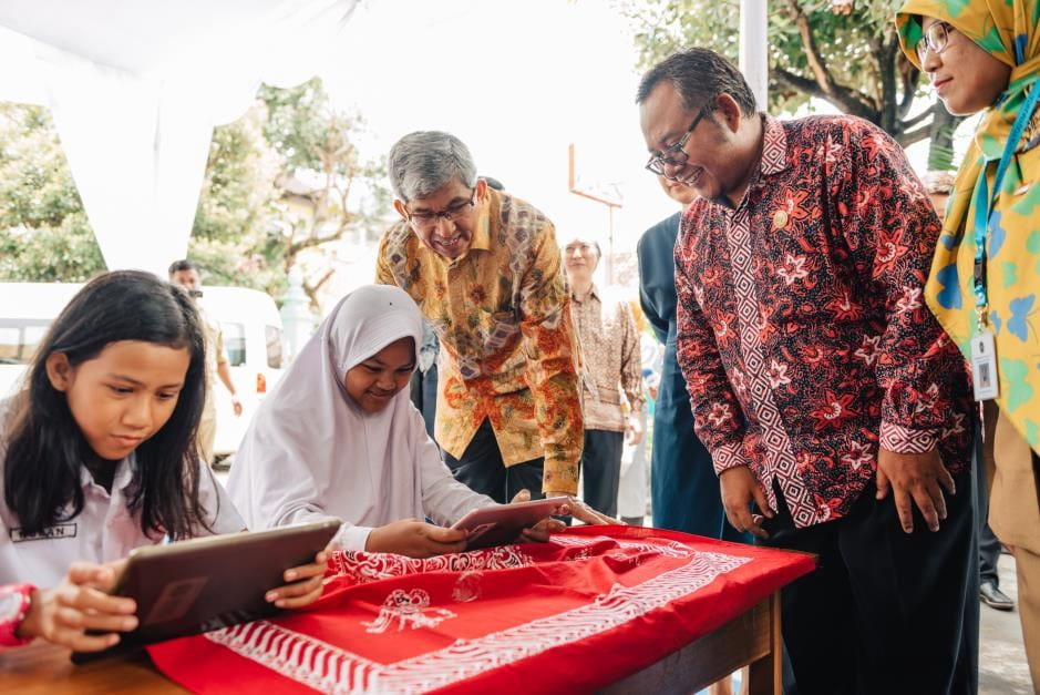 Dr Yaacob Ibrahim (centre) interacting with students of Timuran State Primary School who are learning through educational digital applications via tablets provided from the WoW (Yogyakarta) programme